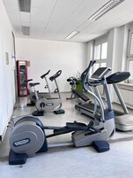 Una palestra con diverse macchine per allenamento, tra cui tapis roulant e cyclette.