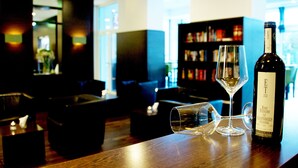 Eine Bar mit einer Weinflasche und zwei Gläsern auf einer Holztischplatte.