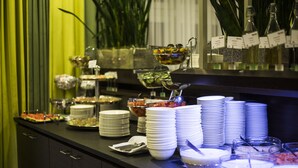 Ein reichhaltiges Buffet mit verschiedenen Speisen und gestapelten Tellern.