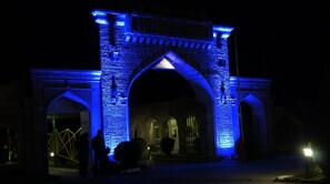 A large stone archway illuminated with blue lights, with a sign reading "INTERNET cafe" above it. - Atlant Holiday Village (Khachmaz)