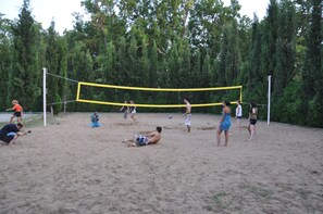 A volleyball game on a sandy court surrounded by trees. - Atlant Holiday Village (Khachmaz)