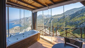 A bathroom with a large bathtub and a view of a mountainous landscape through large windows. - Yediburunlar Lighthouse Boutique Hotel & Restaurant (Seydikemer)