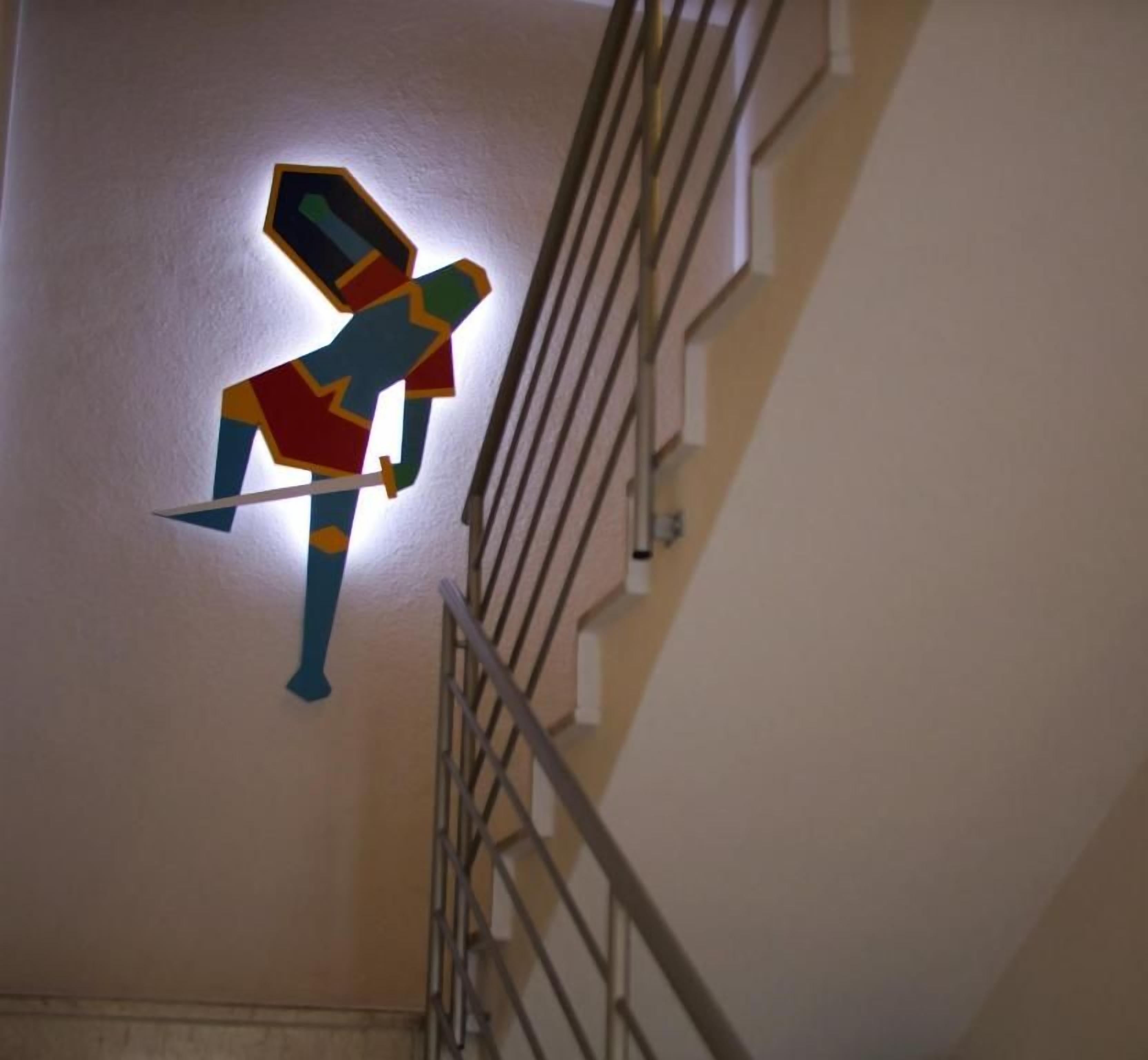 A geometric wall art of a figure holding a sword.