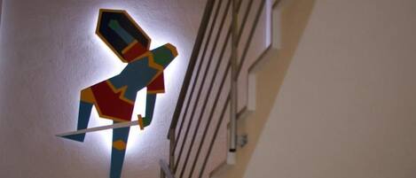 A geometric wall art of a figure holding a sword.