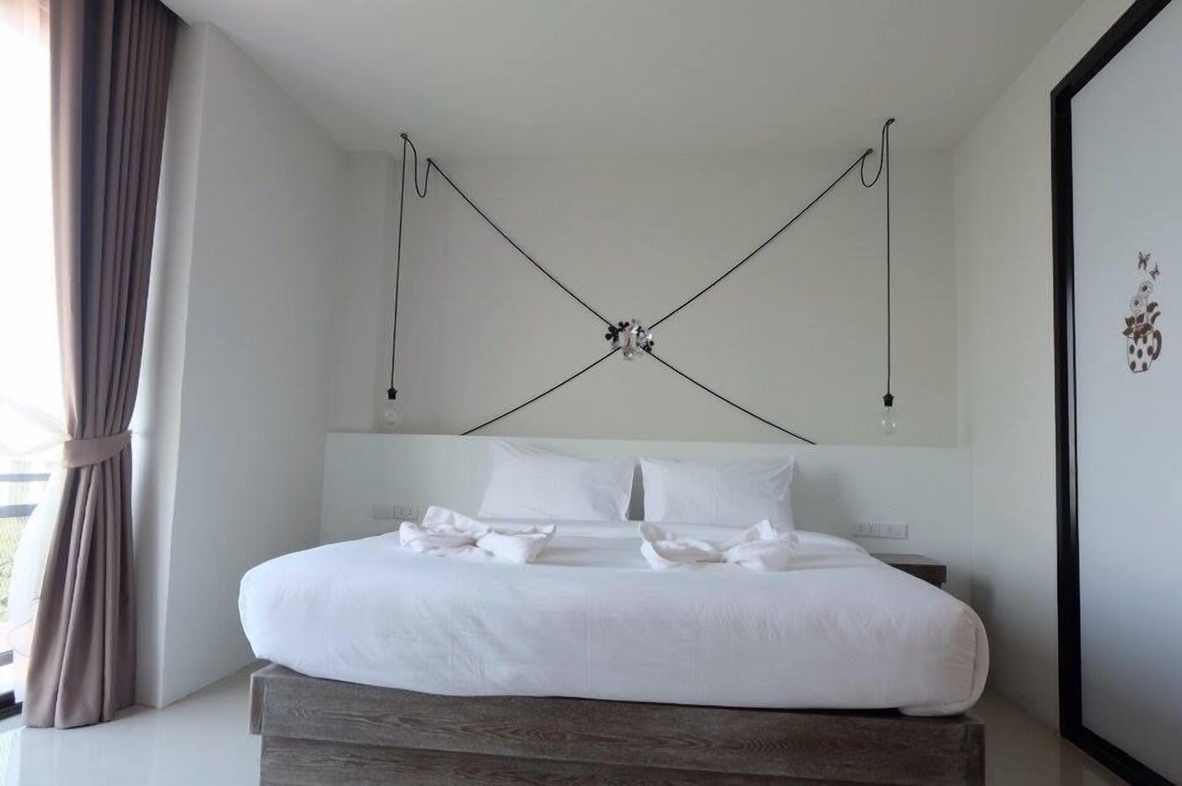 Ein modernes Schlafzimmer mit einem großen Bett, einem Holzkopfstück und einem schlichten, klaren Design.