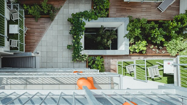 A rooftop terrace with seating areas, a small water feature, and greenery. -  OLIVER urban I Self check-in Apartments (Vienna)