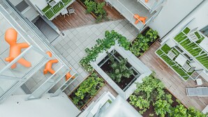 A modern building with multiple floors, outdoor terraces, and orange furniture. -  OLIVER urban I Self check-in Apartments (Vienna)