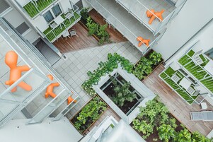 Un edificio moderno con diversi piani, terrazze all'aperto e arredi arancioni.