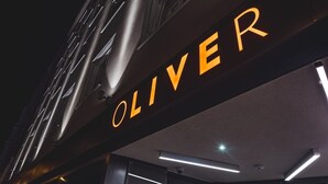 A sign with the name "OLIVER" illuminated in orange. -  OLIVER urban I Self check-in Apartments (Vienna)