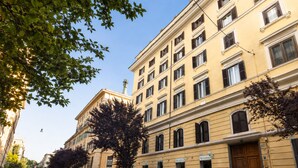 A street lined with parked cars and buildings with multiple windows and doors. - Inside Roma Rooms by DOT Suites (Rome)