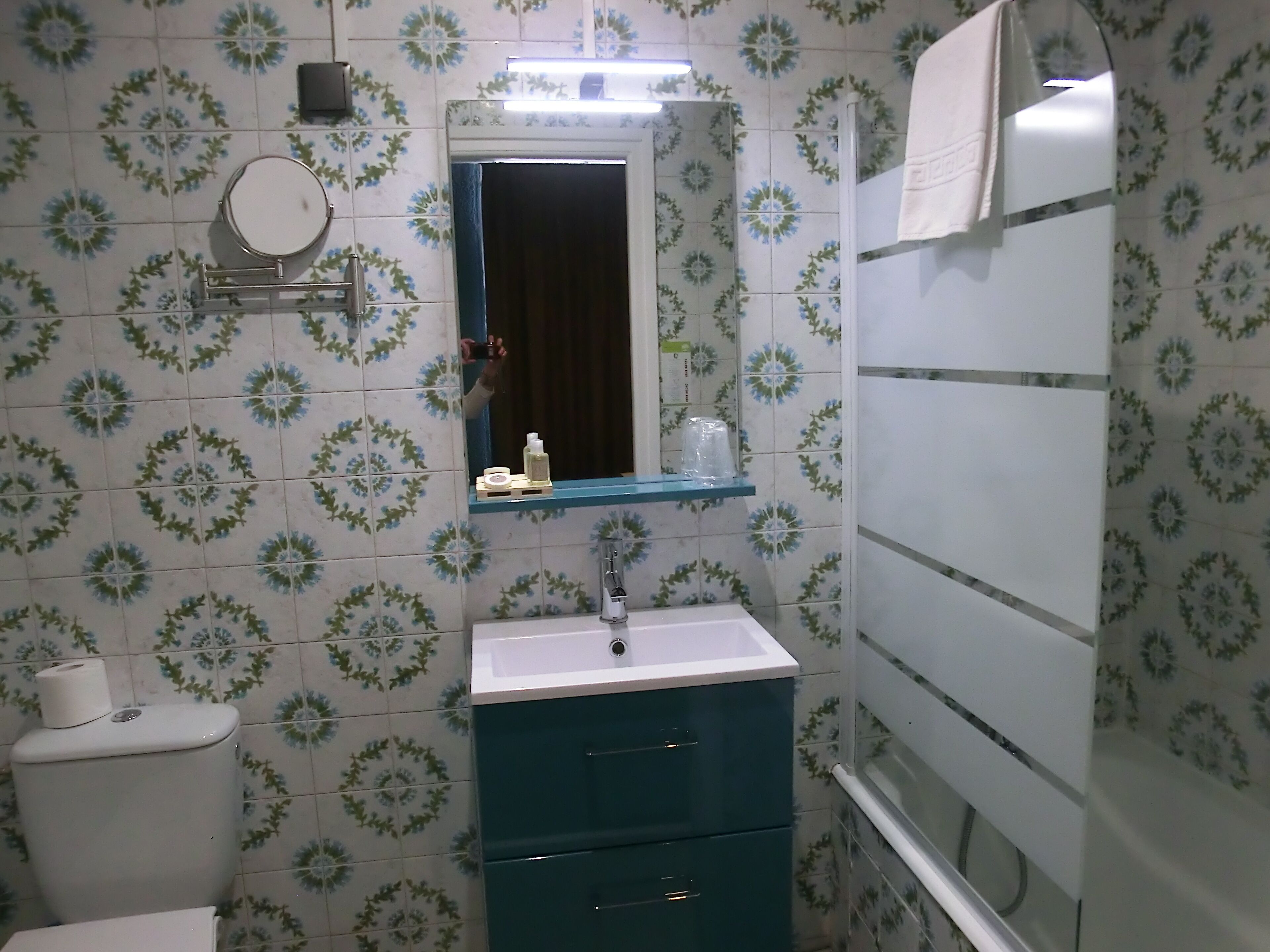 Une salle de bain équipée d’un WC, d’un lavabo, d’un miroir et d’un porte-serviettes.
