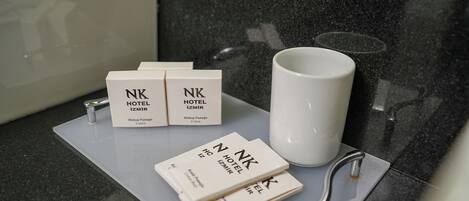 A hotel reception area with a counter displaying a white mug and several hotel brochures.