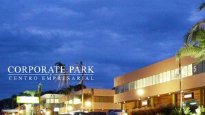 Un bâtiment moderne, sur lequel on peut lire, la nuit, l’inscription « CORPORATE PARK CENTRO EMPRESARIAL ».