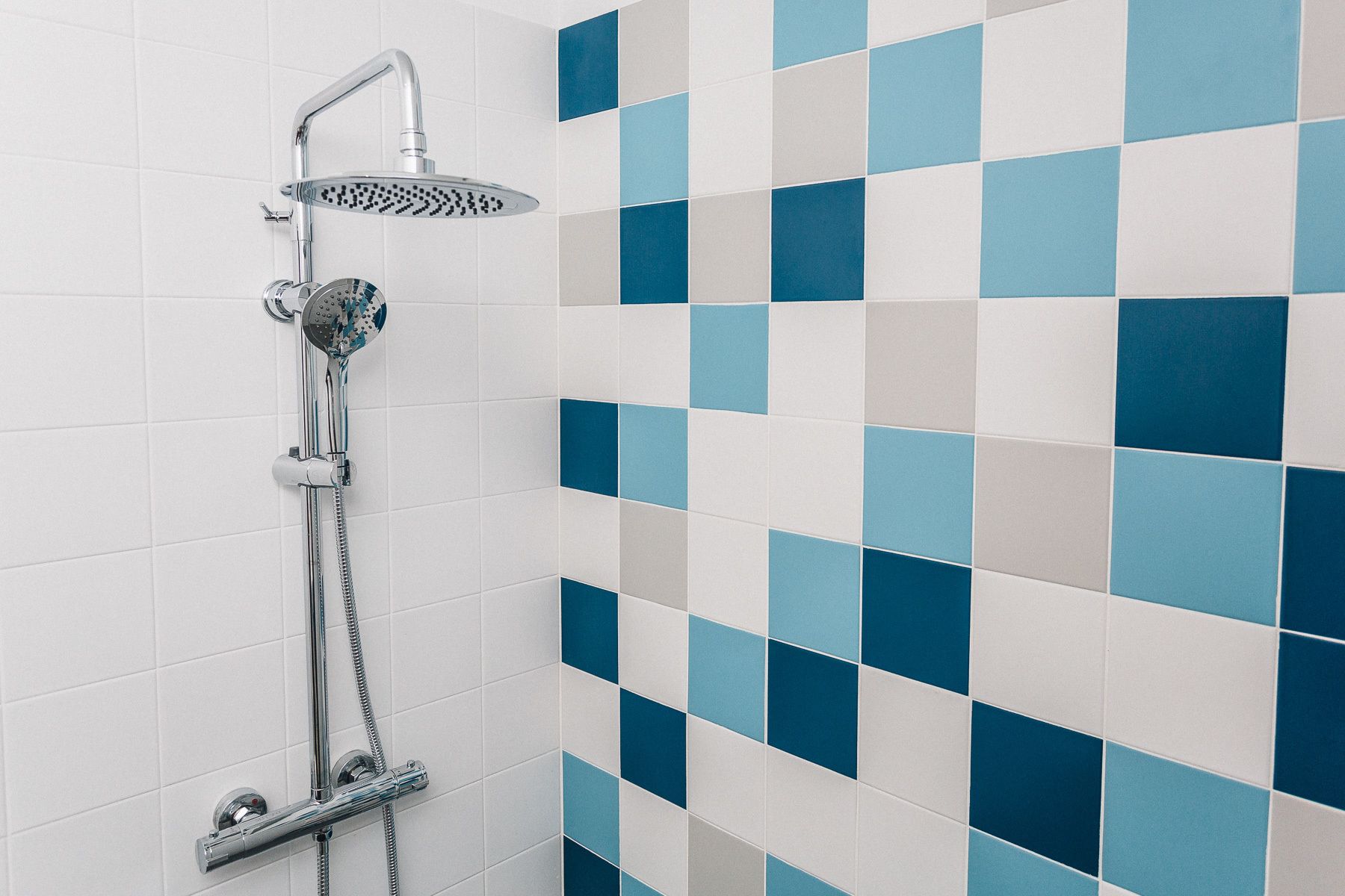 Eine Dusche mit Handbrause und Deckenbrause.