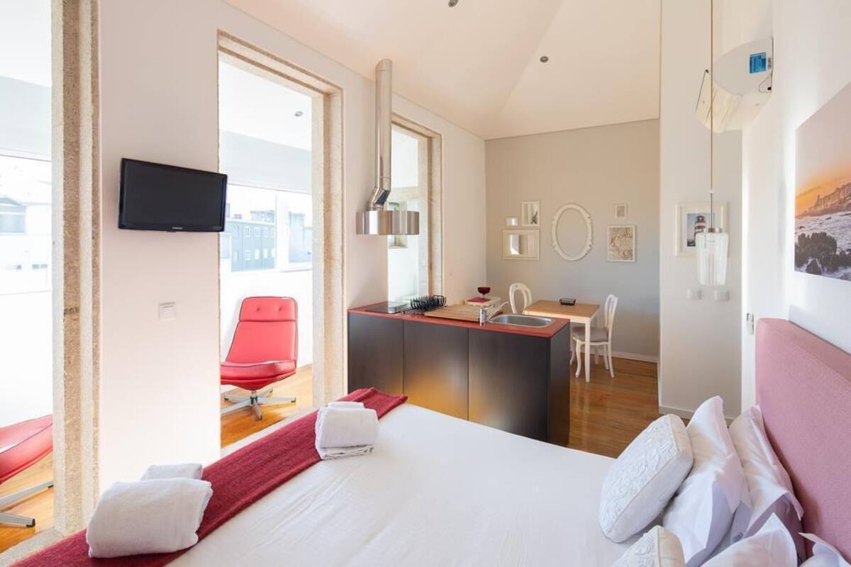 Una habitación de hotel con cama, escritorio, silla y televisor.