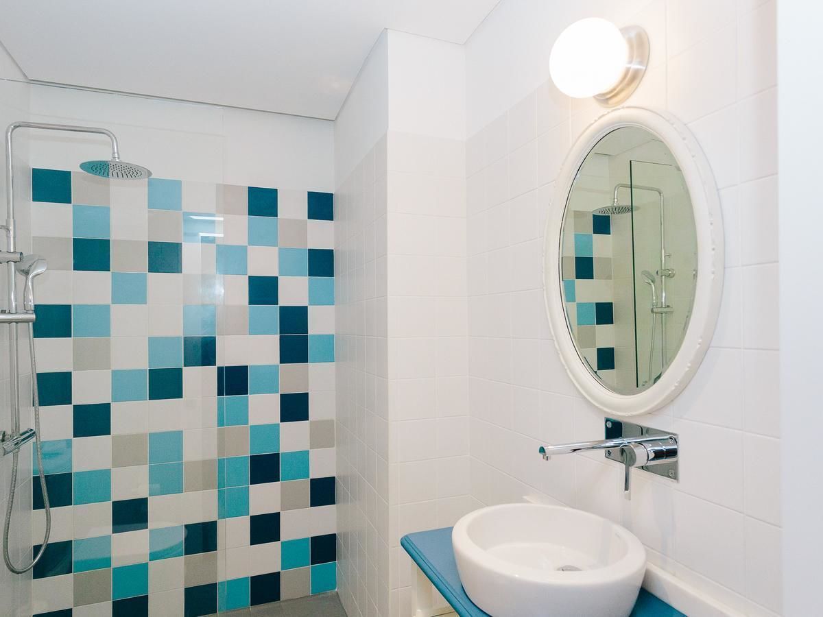 Une salle de bain avec une douche, un lavabo et un miroir.
