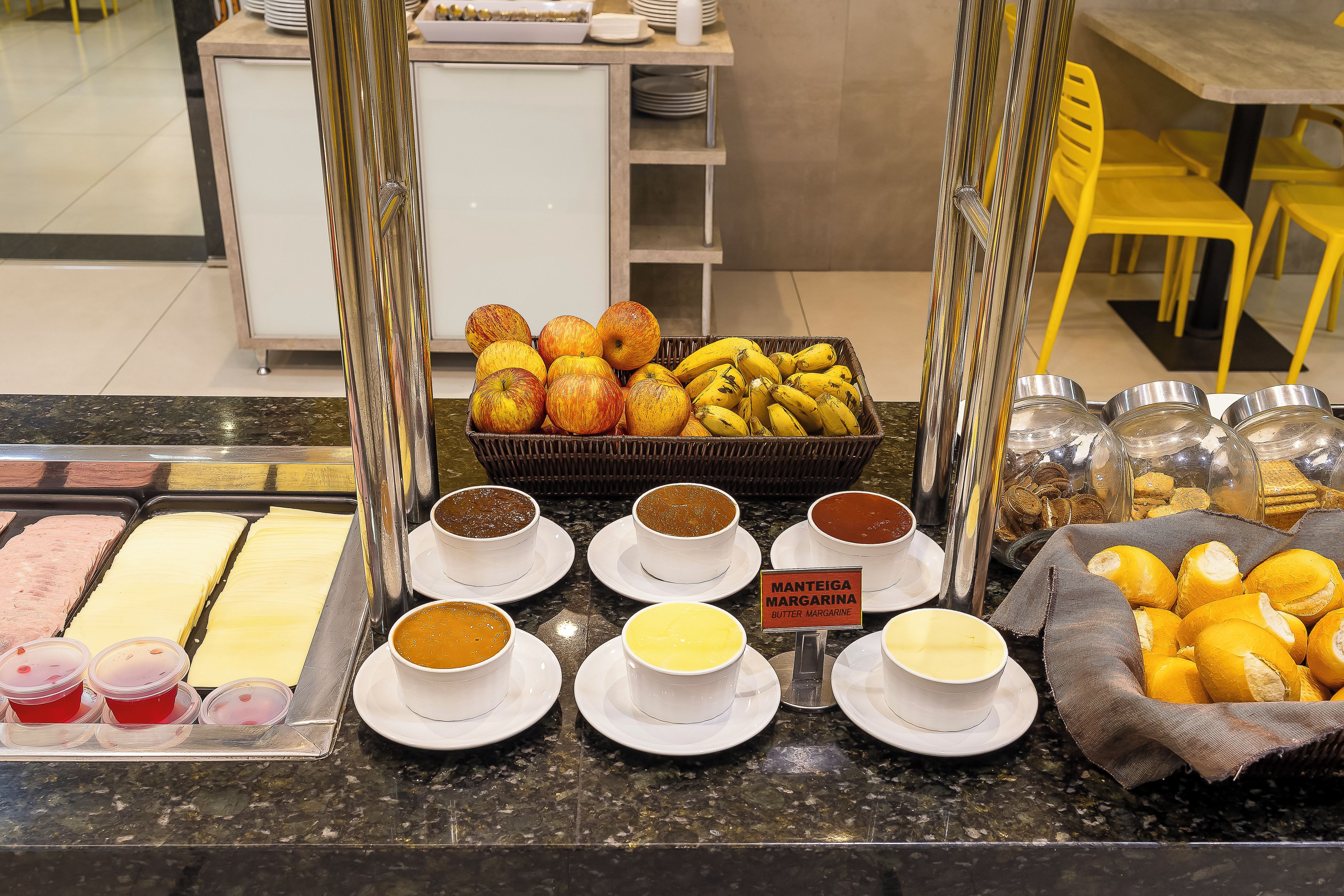 Un bufé con diversos alimentos y un letrero que dice 'Manteiga Margarina'.