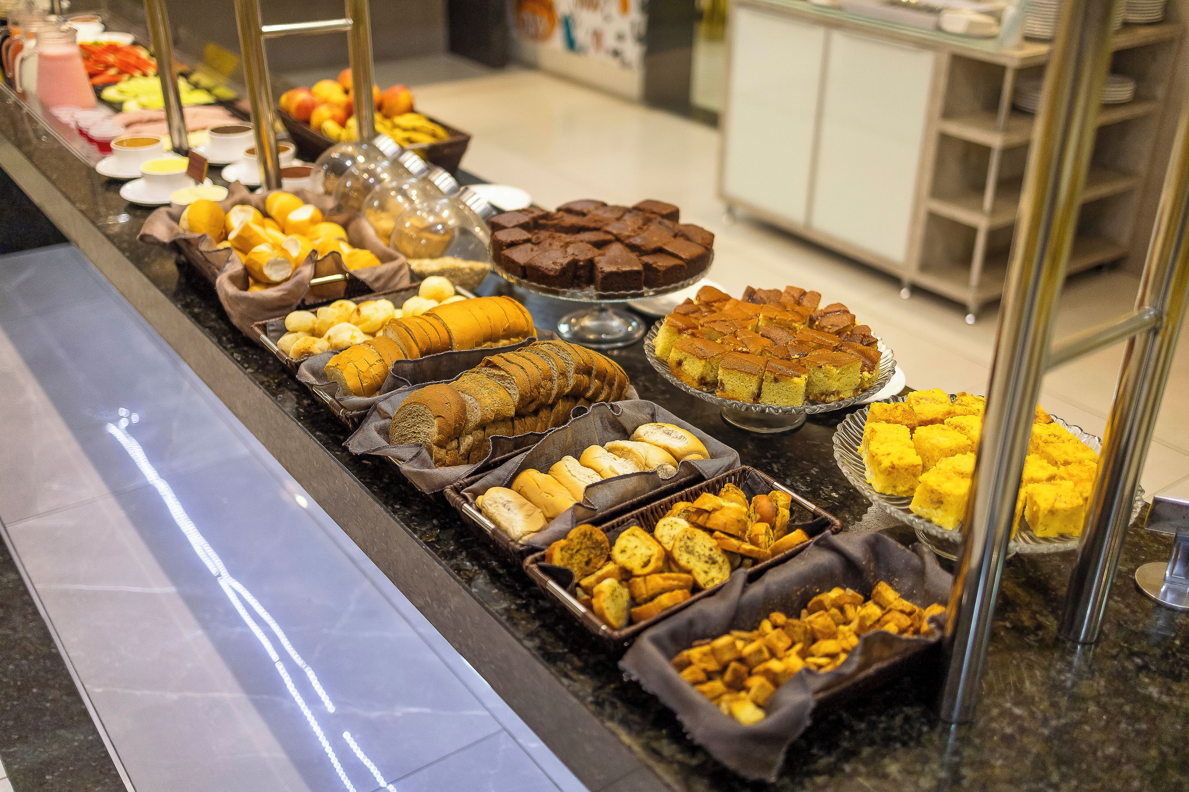 Un bufé con diversos alimentos, incluyendo pan, bollería y postres.