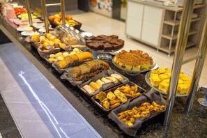 A buffet with various food items including bread, pastries, and desserts. - Hotel Avalon Maringá (Maringá)