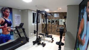 A gym with cardio equipment, weight machines, and a mirror. - Hotel Avalon Maringá (Maringá)