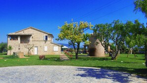 Un patio empedrado con un edificio de techo a tejas y una chimenea de ladrillo.