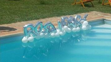 Zwembad met metalen letters waarop ‘RODNEY’ staat en witte ballonnen.