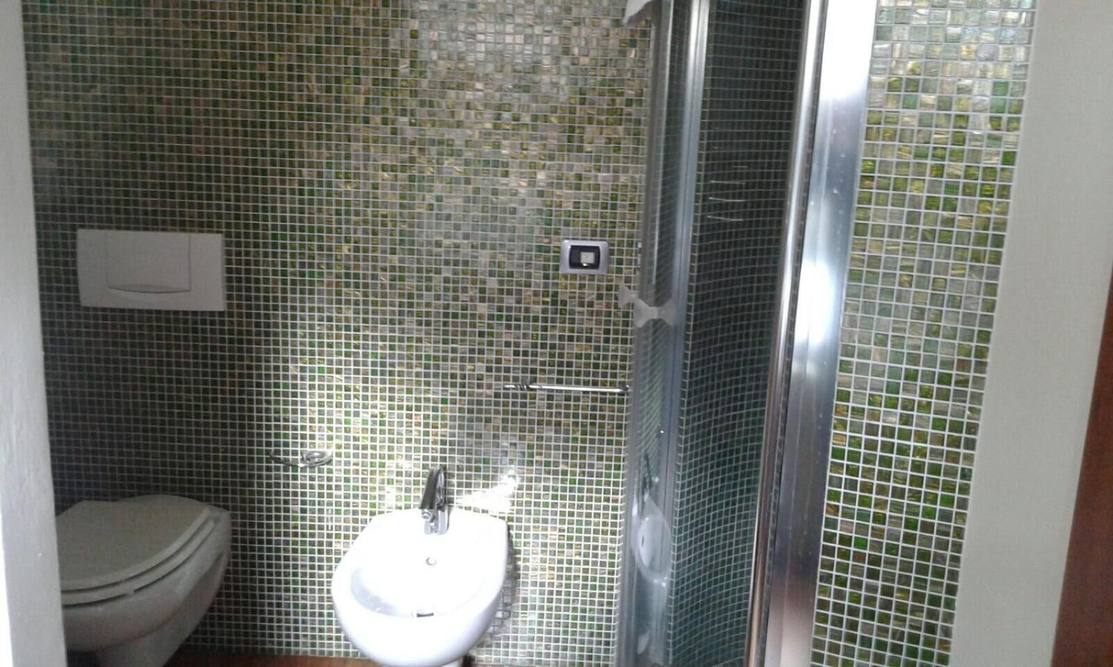 Ein Badezimmer mit Toilette, Waschbecken und Duschbereich.