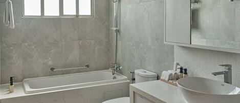 Un baño moderno con bañera, inodoro y lavamanos.