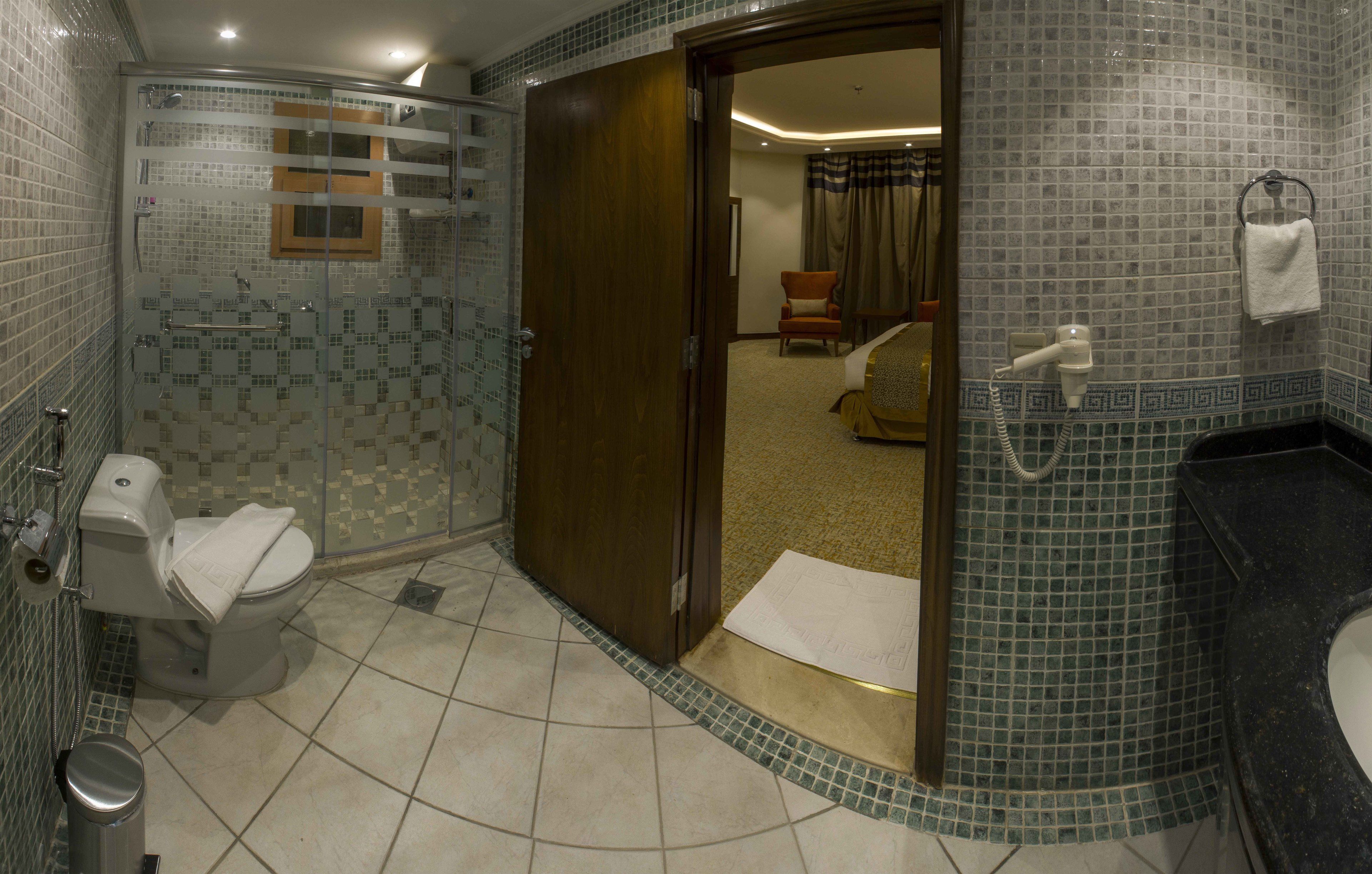 A bathroom with a shower, toilet, and sink.