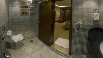 A bathroom with a shower, toilet, and sink.