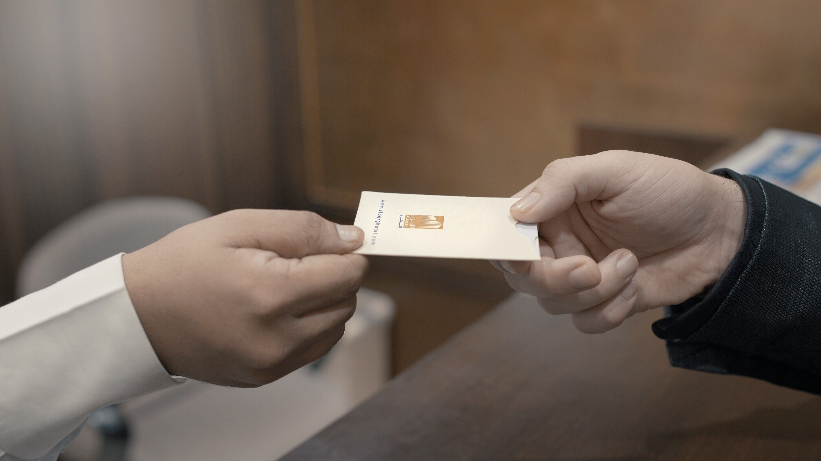 A person handing over a business card to another person.