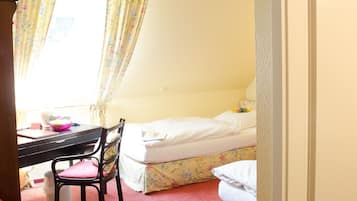 A room with a bed, a desk, and a chair.