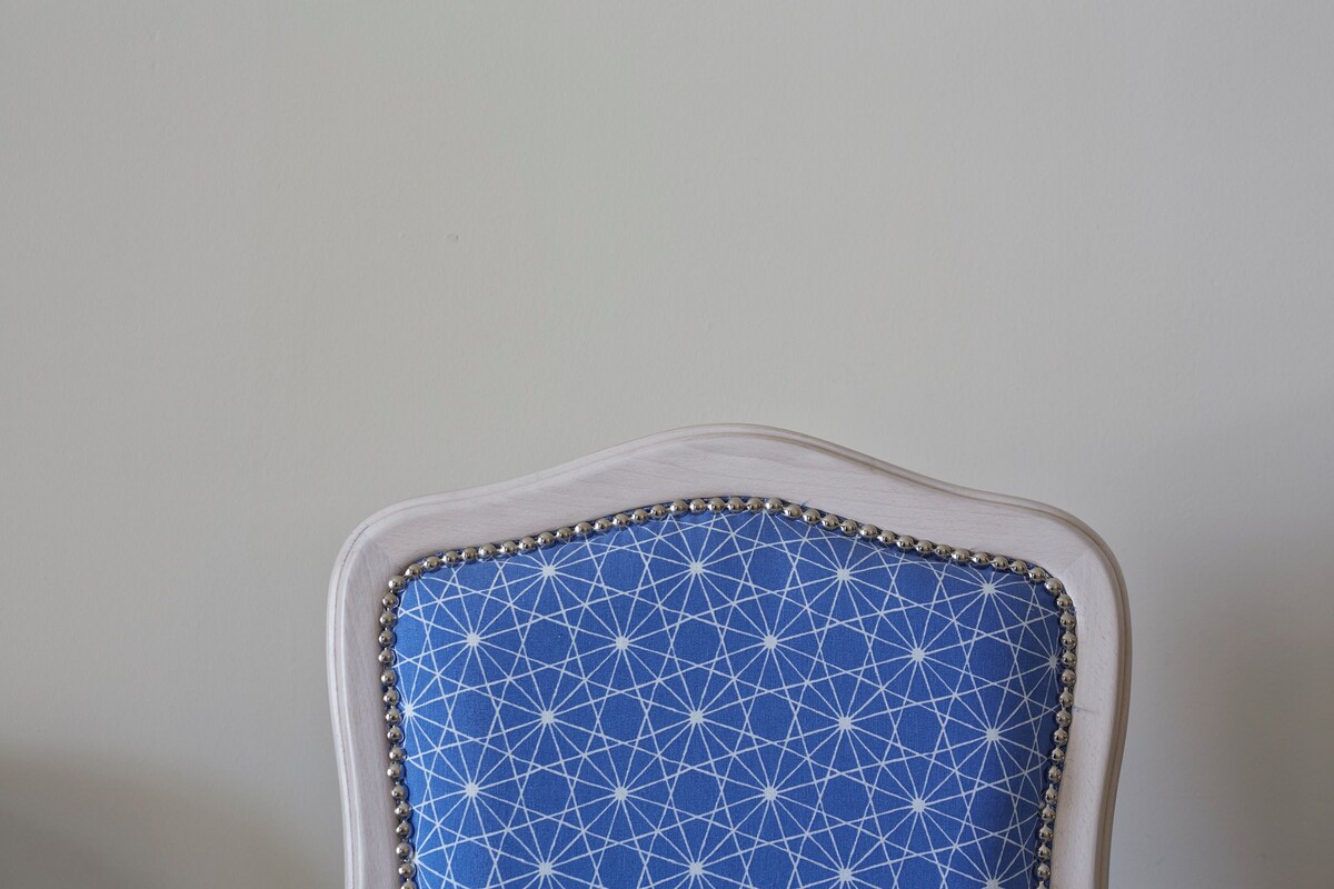 A chair with a geometric pattern and a beaded trim.