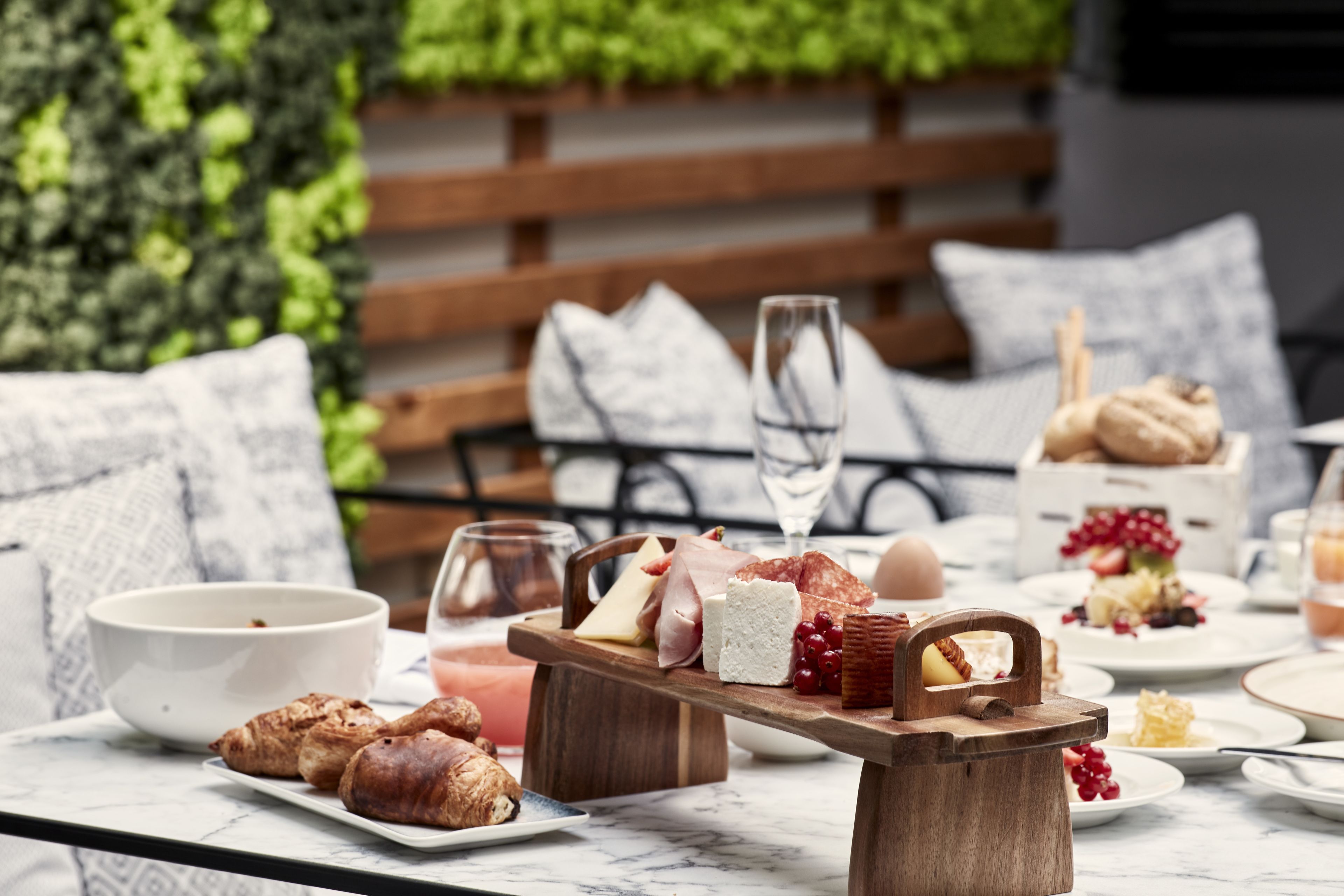 Un'impostazione per la colazione con diversi cibi e bevande su un tavolo, tra cui pasticceria, formaggio e un cesto di frutta.
