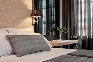 A hotel room with a bed, a bedside table with a book, a lamp, and a plant. - Antigon Urban Chic Hotel (Thessaloniki)