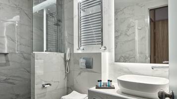 Een moderne badkamer met een grote spiegel, een inloopdouche en een wastafelmeubel met een ruime wasbak.