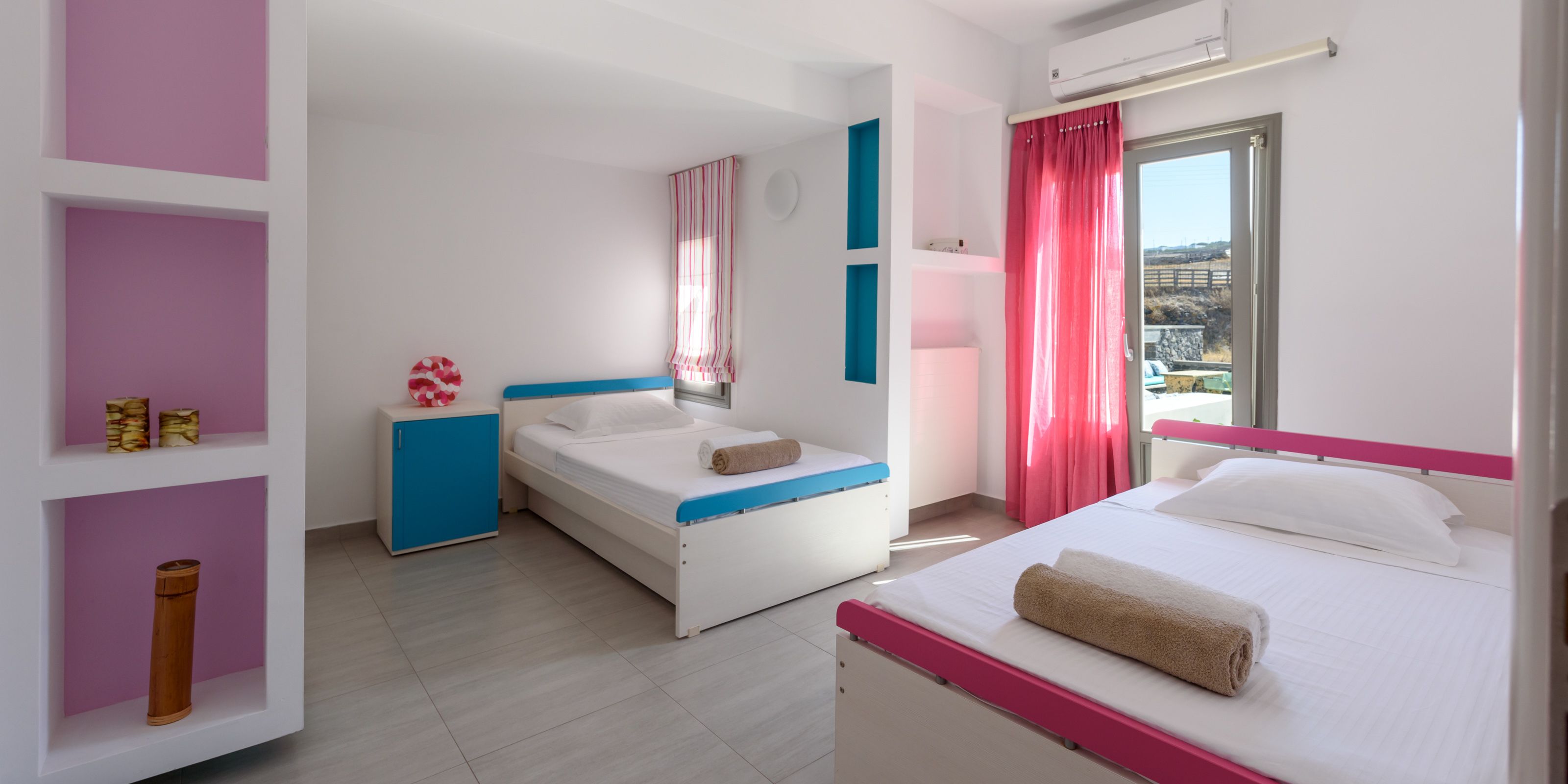 Habitación de hotel con dos camas, un escritorio pequeño y ventana con vistas.