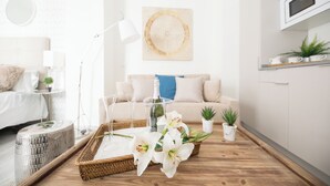 A modern living room with a wooden coffee table, a sofa, a lamp, and a wall-mounted TV. - Apartamentos Soho Boutique Museo (Málaga)