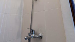 Een douche met een handdouche en een wandmengkraan.
