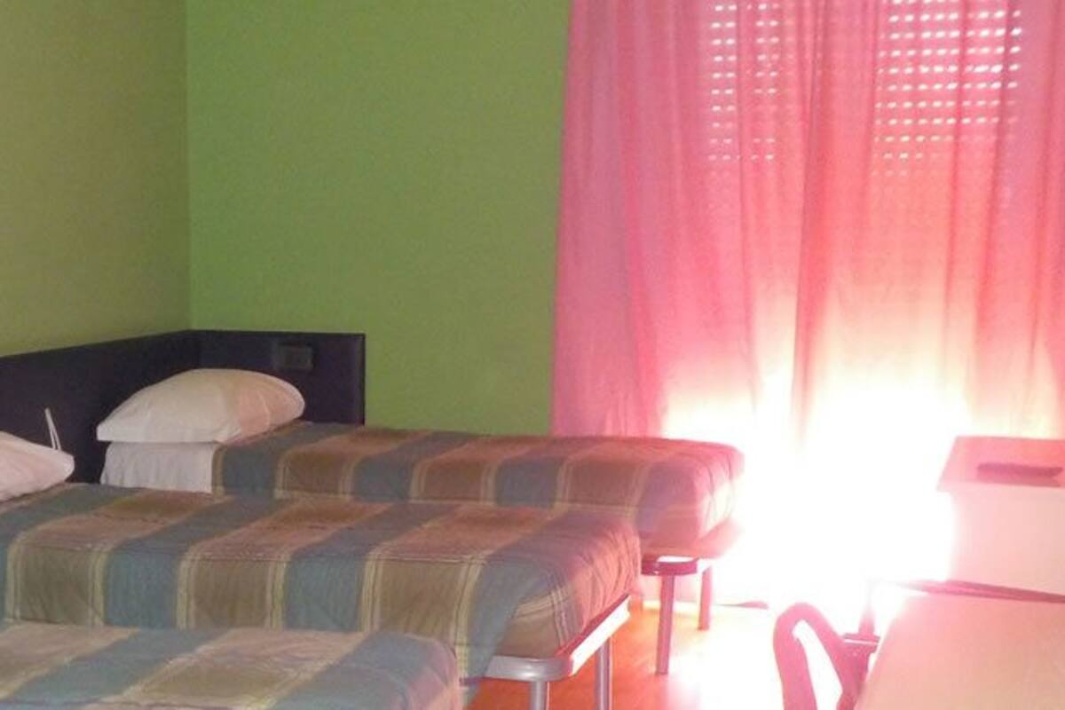 A room with two beds, a desk, and a chair.