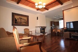 A living room with a fireplace, wooden furniture, and a television. - Country Club Pihtovoe (Vysotsk)