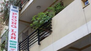 A building with a sign for 'Orchid Guest House' on the side. - Phong Lan Guesthouse (Hue)