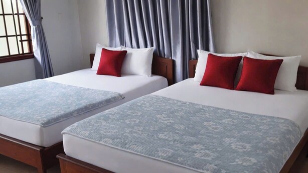 Two double beds with white and red bedding, wooden headboards, and a window with curtains. - Phong Lan Guesthouse (Hue)