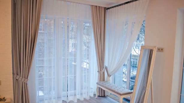 Una habitación con ventanas amplias, un banco y un espejo.