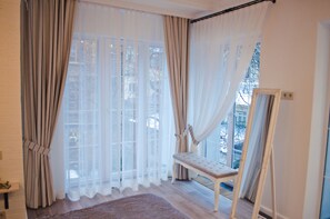 A room with large windows, a bench, and a mirror. - Dom Rabinovicha (Odesa)