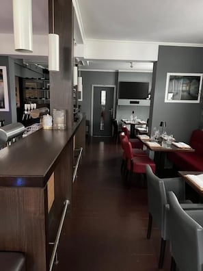 A modern restaurant with a bar area, dining tables, and chairs. - Hotel Restaurant Zum alten Postwagen (Gevelsberg)