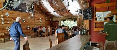 Un café rústico con paredes de madera y faroles colgantes.