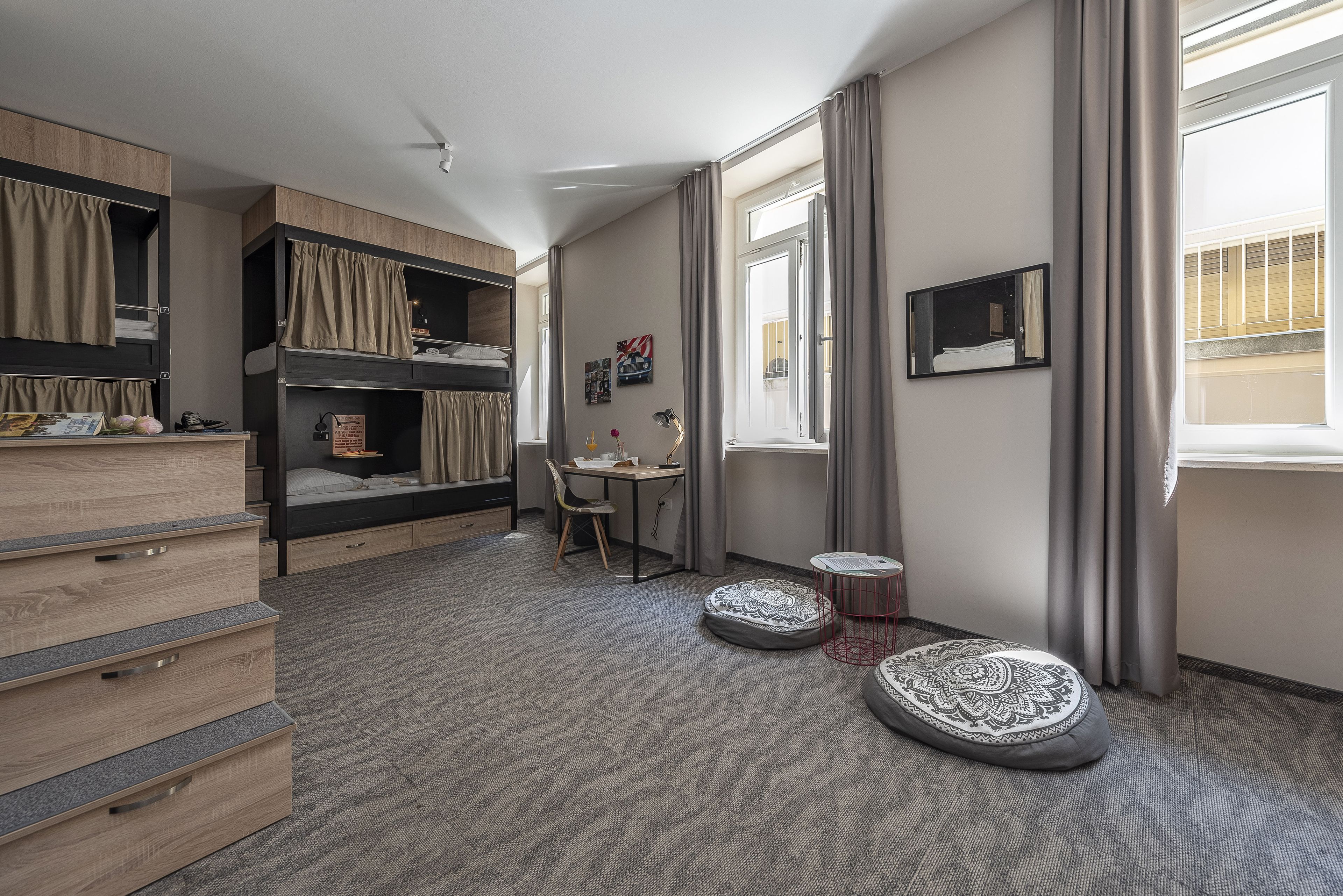 A compact room with bunk beds, a desk, and a chair.