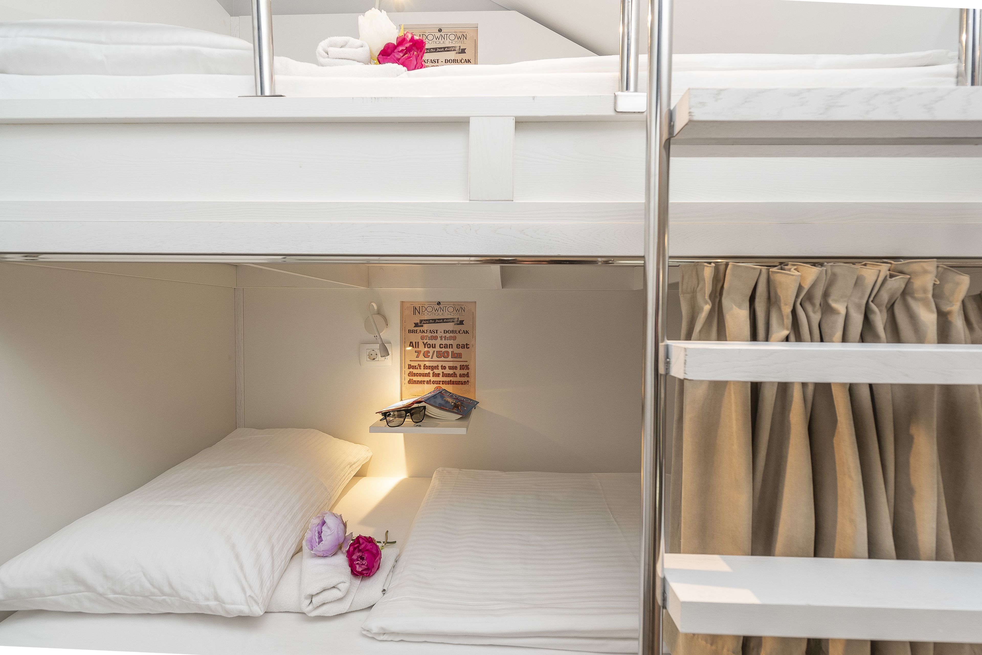 A bunk bed room with a sign advertising breakfast and a discount offer.