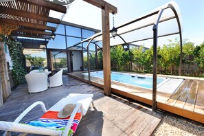 A wooden deck with a hot tub, white wicker chairs, and a pergola. - Aquaduct Hotel (Mateh Asher)